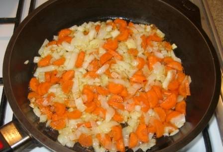 Добавьте морковь к луку, жарьте еще 5 минут. Затем переложите овощи в тарелку.