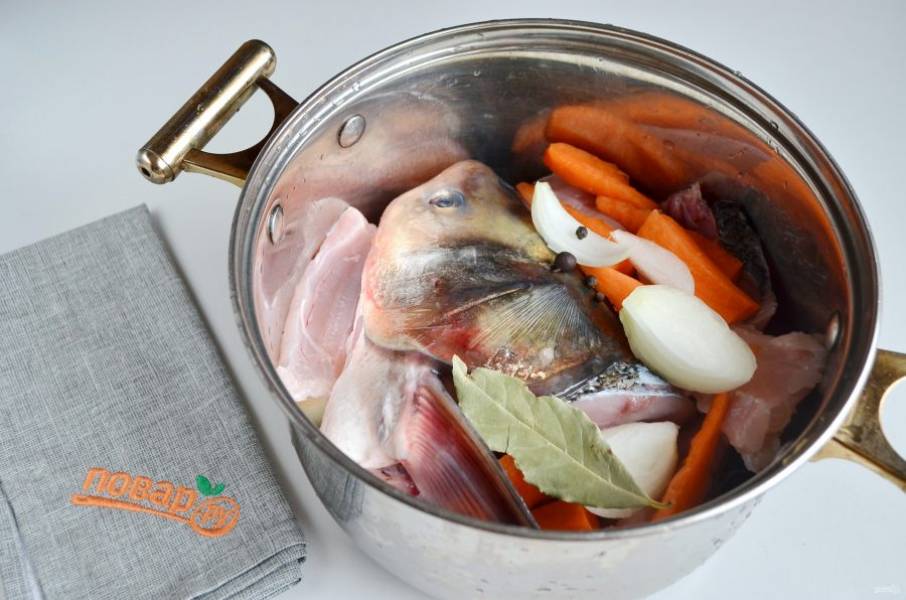  2. В кастрюлю положите рыбные продукты, лук (порезанный на 2-4 части), морковь (порезанную на 6-8 частей), лавровый лист, перец горошком, залейте холодной водой. Варите при слабом кипении (после момента закипания) 30 минут.