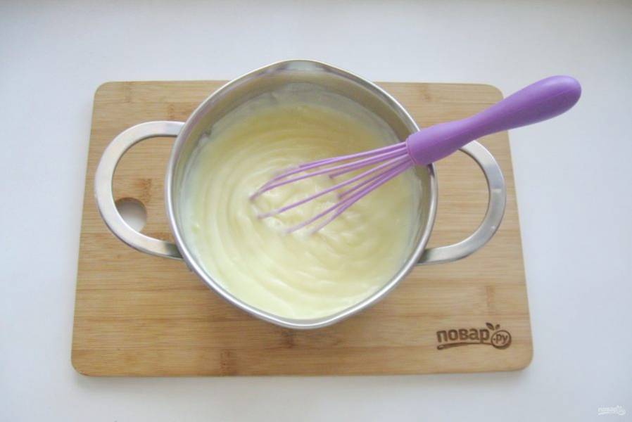 Приготовьте заварной крем. В кастрюлю налейте молоко и поставьте на плиту. В мисочке смешайте желтки, сахар и крахмал. Налейте 3-4 столовые ложки молока и хорошо перемешайте, чтобы не было комочков. Когда молоко начнет закипать, влейте в кастрюлю приготовленную смесь. Постоянно перемешивая венчиком, доведите крем до загустения.