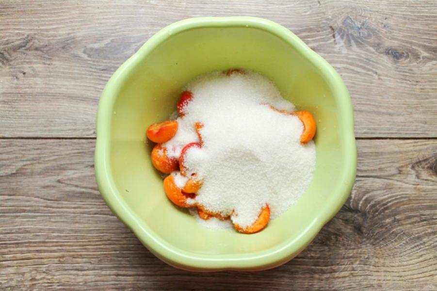 Всыпьте к абрикосам сахар и поставьте на два часа в холодильник.