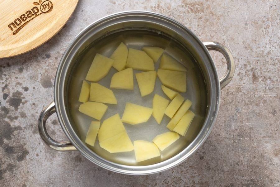 Вскипятите воду в кастрюле. Добавьте очищенный и порезанный ломтиками картофель. Варите 10 минут.