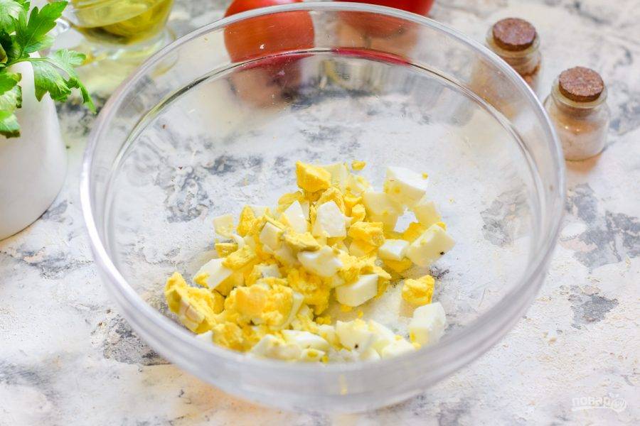 Куриное яйцо отварите вкрутую, почистите и нарежьте кубиками, переложите в салатник.