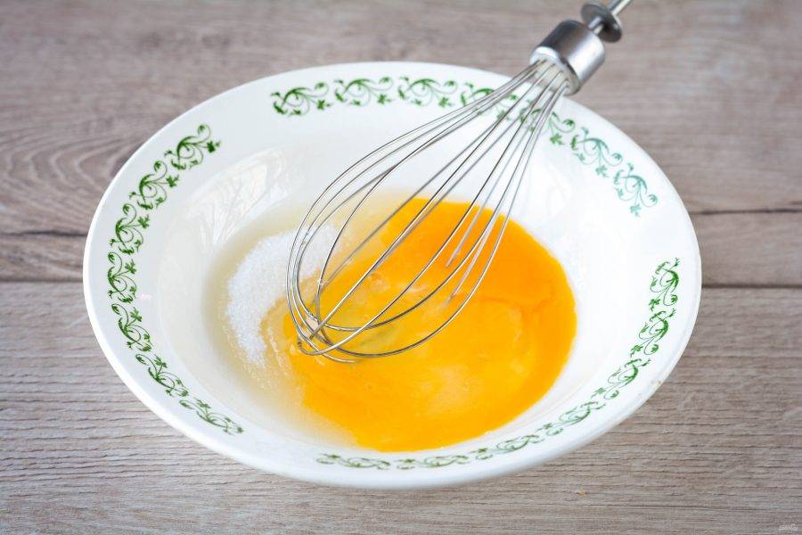 Смешайте сахар с куриным яйцом, взбейте венчиком до растворения кристаллов. Добавьте ванильный сахар, соль и снова взбейте.
