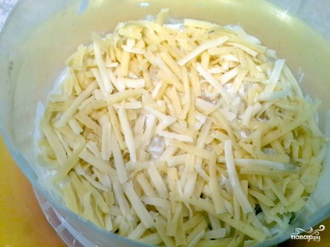 Сыр трем на крупной терке. Половину сыра высыпаем на ананасы.