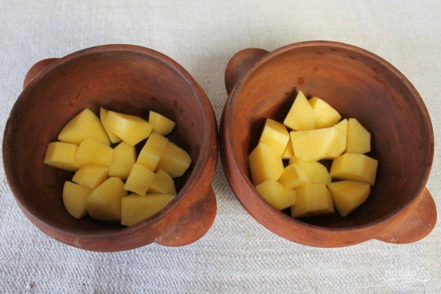 В глиняные горшочки кладем нарезанный кусочками картофель. 