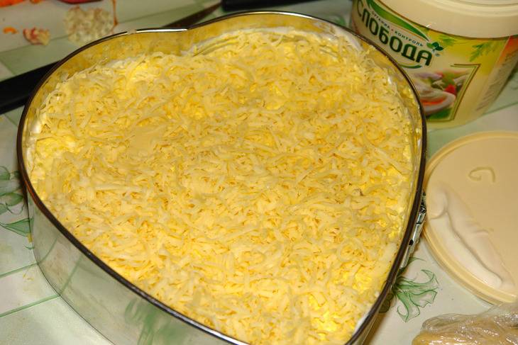 4. Далее выложить слой тертых на терке белков и немного промазать майонезом. Сыр натереть на терке и выложить в форму.