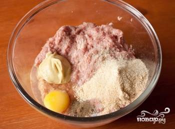 1.	В миску отправляем фарш (свиной, говяжий), вбиваем яйцо, очищаем и нарезаем мелко луковицу, отправляем её туда же. Затем добавляем горчицу, панировочные сухари, солим и перчим.
