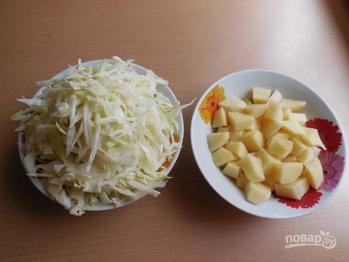 Пока займитесь овощами. Очищенный картофель нарежьте кубиками, а капусту нашинкуйте соломкой.