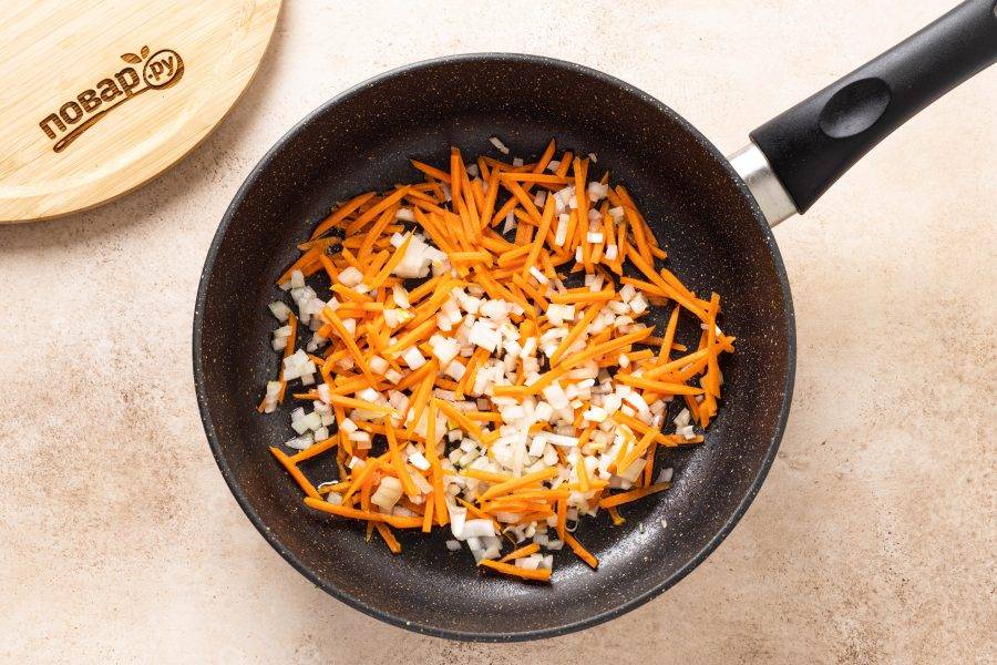 Репчатый лук нарежьте на мелкие кубики, морковь очистите и натрите на терке. Обжарьте в сковороде с растительным маслом до золотистого цвета.