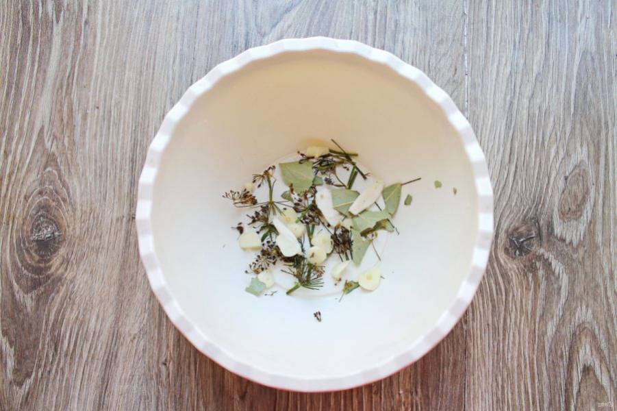 В тару для засолки насыпьте немного соли с перцем, частью листьев смородины, лавра и укропа. Чеснок почистите и порежьте, часть выложите на дно и добавьте немного порезанного корня хрена.