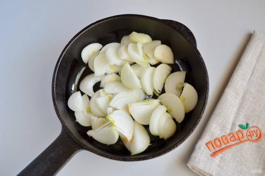 2. Очистите лук и порежьте полукольцами. Обжарьте на растительном масле до мягкости. Добавьте щепотку соли.
