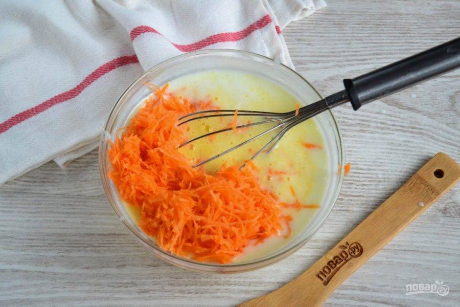 Морковь натрите на мелкой терке и добавьте в тесто для оладий. Перемешайте.