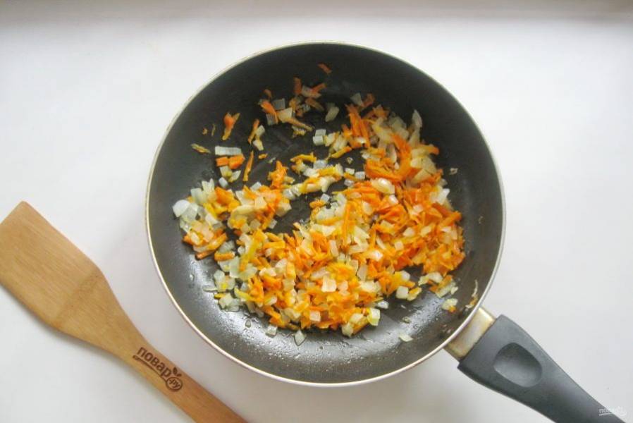 Налейте подсолнечное масло и пассеруйте лук с морковью на небольшом огне 7-8 минут перемешивая.