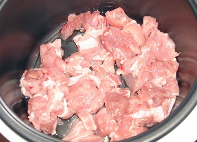 Для начала мясо промываем и нарезаем его на небольшие кусочки, выкладываем его в чашу мультиварки. 