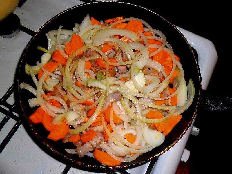 Затем морковь отправляю на сковородку к остальным ингредиентам. Пассирую до появления золотистого оттенка.