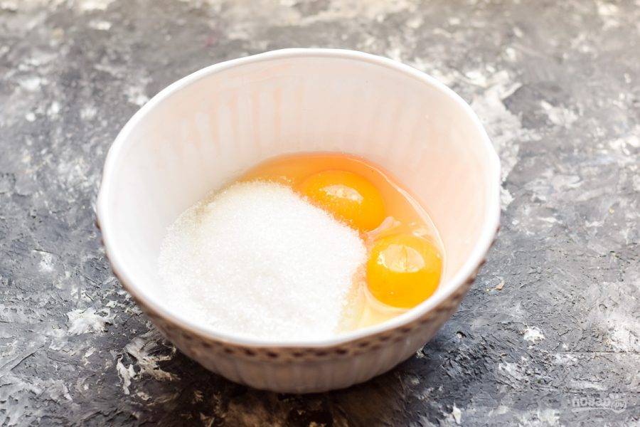 В миску вбейте яйца, добавьте сахар. Взбейте ингредиенты несколько минут.