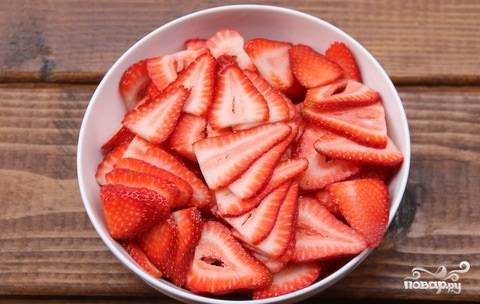 7. Вымойте и как следует обсушите ягоды. Нарежьте их тонкими ломтиками, оставив несколько клубничек целиком для украшения. 