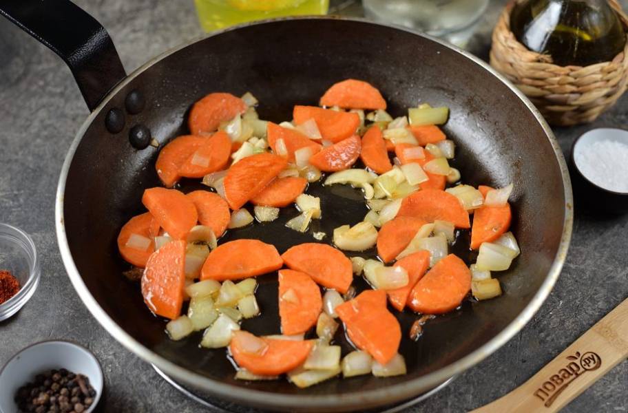 Грибы также переложите на тарелку, подлейте еще немного масла и обжарьте измельченные лук, чеснок и морковь около минуты.