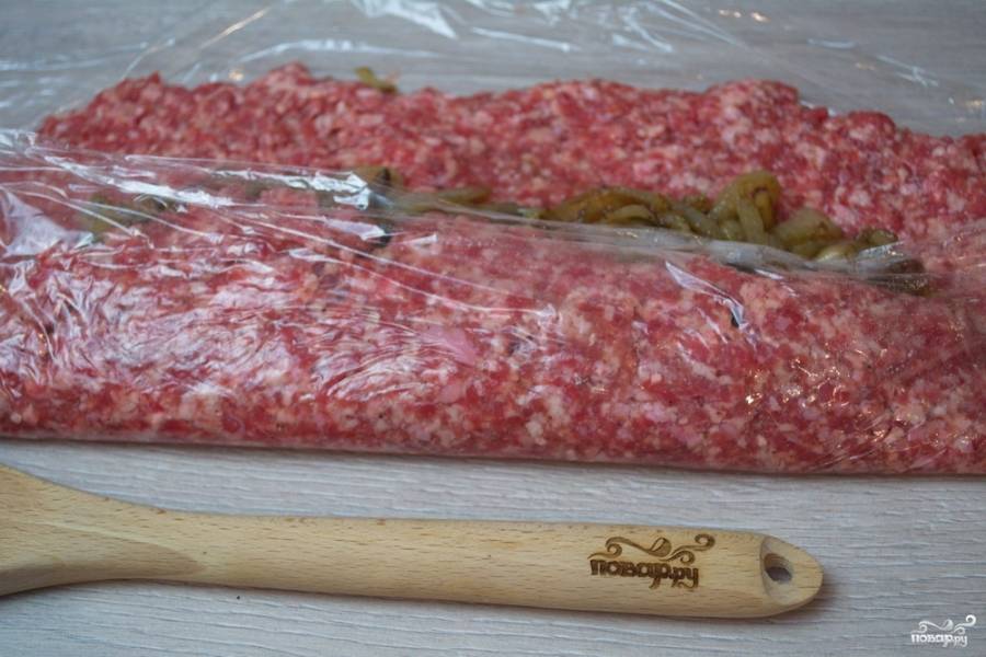 При помощи пленки поднимите 1 край, сверните мясной пласт в рулет.