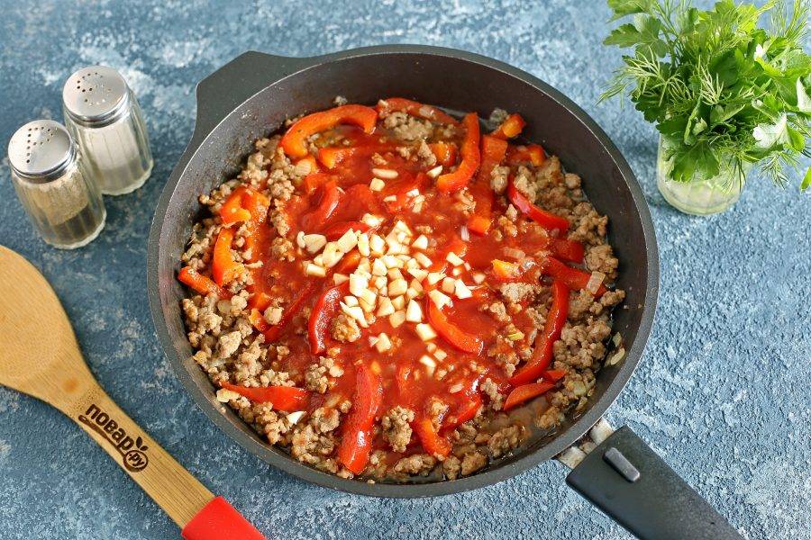 Добавьте томатный соус и нарезанный кубиками чеснок. По желанию можно добавить немного воды.