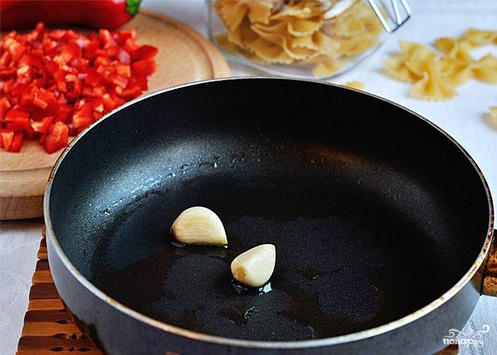На разогретую сковороду наливаем масло, обжариваем чеснок, пока он не отдаст аромат. Чеснок убираем и обжариваем перец. Одновременно в течении 7 минут варим макароны.