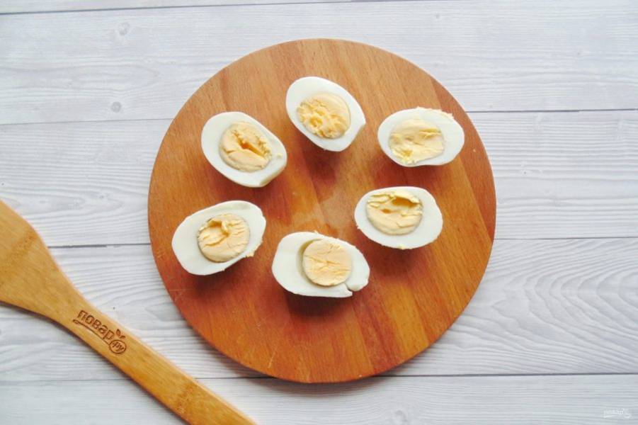 Яйца отварите, охладите и очистите. Аккуратно разрежьте вдоль на половинки каждое яйцо. Отделите желток от белка.