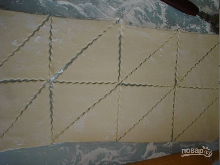 Разморозьте слоеное тесто, раскатайте его в пласт. Потом разрежьте на квадраты, а квадраты порежьте на треугольники. 