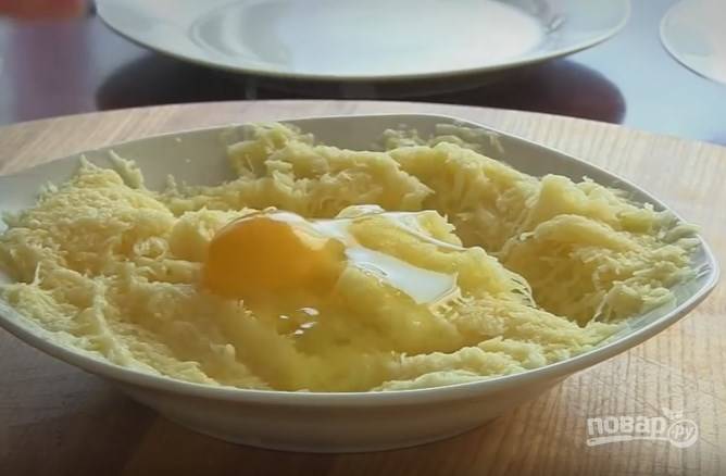 4. Картофель нужно очистить и натереть на мелкой терке. Посолите и слейте лишнюю жидкость. Добавьте яйцо, перемешайте. 