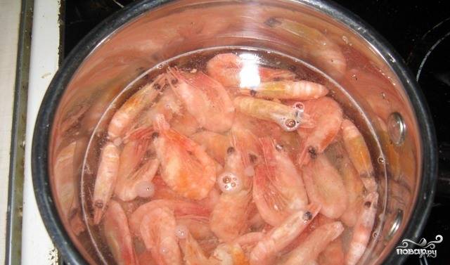 Отварите креветки до готовности в подсоленной воде. Если вы хотите добавить морепродуктам пикантности, добавьте в кастрюльку специй и жгучего перца. 