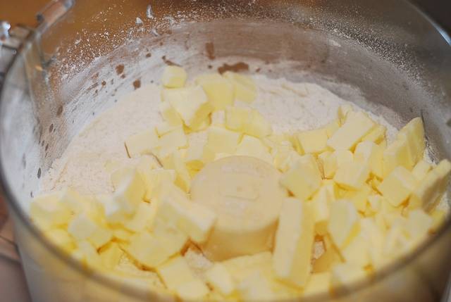 1. Муку необходимо просеять с солью и добавить сахар. Тщательно перемешать (можно использовать для этого кухонный комбайн) и добавить нарезанное небольшими кусочками холодное сливочное масло. 