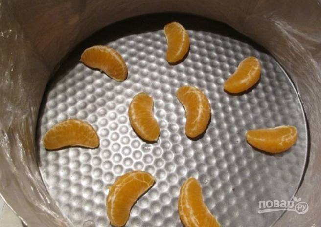 Фрукты очищаем. На дно разъемной формы выкладываем дольки мандаринок.