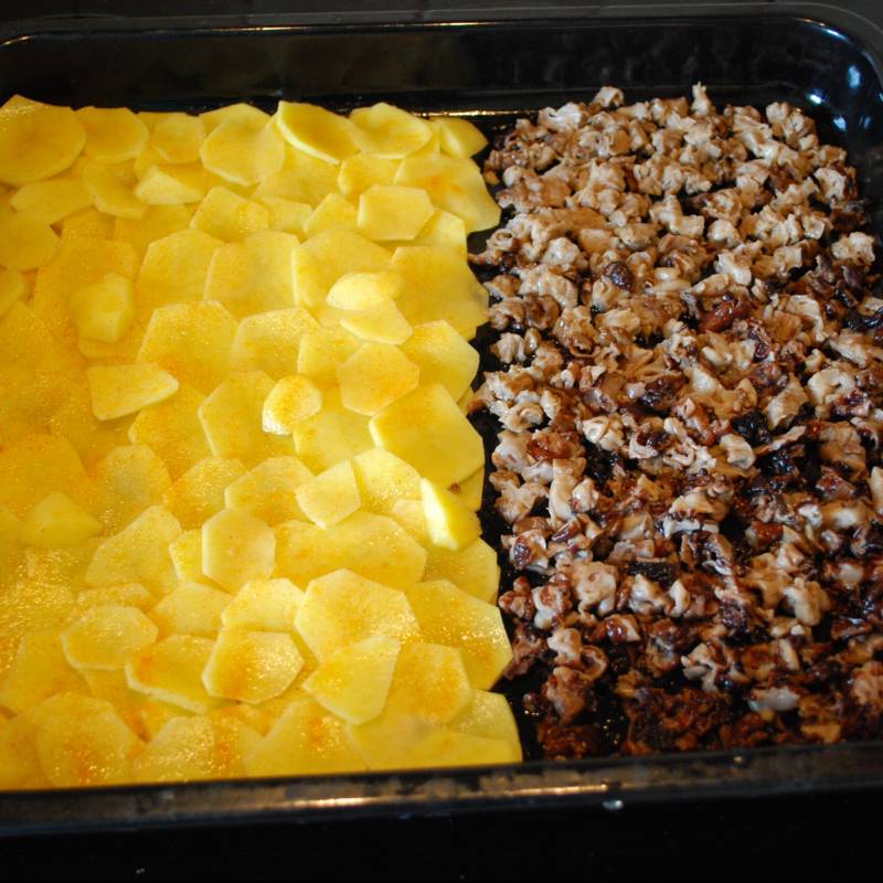 Грибы порезать на маленькие кусочки, картошку порезать кружочками и выложить все это на противень. Картошку слегка посыпать приправой для картофеля или куриным бульоном.