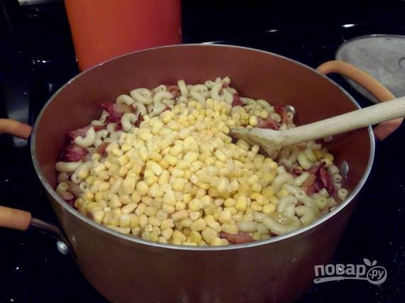 К отваренным макаронам выложите содержимое сковороды и кукурузу.