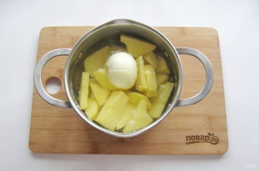 Лук очистите, помойте и добавьте в кастрюлю с картошкой.