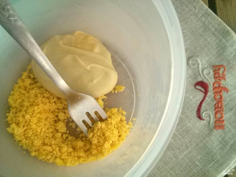 Яичный желток раскрошите с помощью вилки, добавьте пару ложек майонеза и тщательно перемешайте до однородности. 
