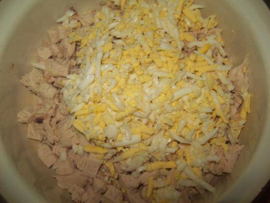 На крупной терке натрите сваренные яйца и твердый сыр, соедините их с куриным филе.