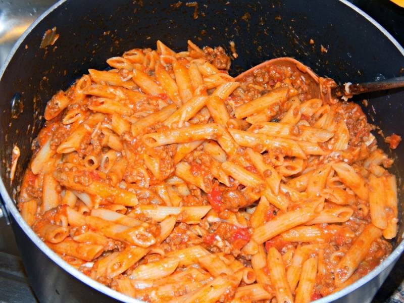 4. Отваренные макароны добавит к томатно-мясному соусу, тщательно перемешать и подержать на огне около 2 минут. 