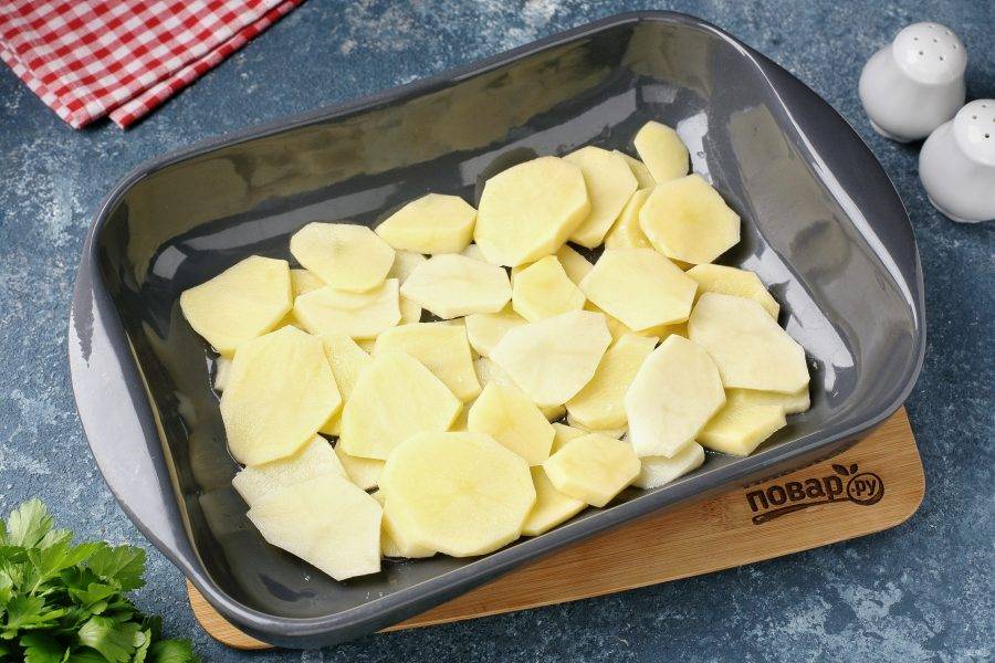 Форму для выпечки смажьте маслом. Картофель нарежьте тонкими кружочками и выложите ровным слоем, посолите и поперчите по вкусу.