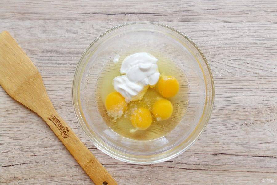 Яйца разбейте в миску. Добавьте соль и сметану.