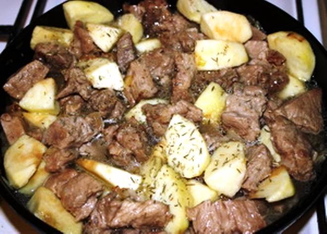 Верните мясо на сковороду, добавьте порезанные яблоки, бульон и тимьян. Доведите до кипения и тушите под крышкой в течение 40 минут. Затем разложите мясо и фрукты по тарелкам.