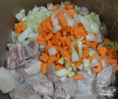 2. Добавьте крупно нарезанную морковь и лук после того, как свинина слегка обжарится и изменит цвет.