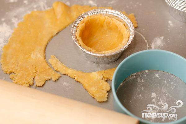 3.	Тонким слоем (примерно три-пять миллиметров) раскатываем охлажденное тесто. Вырезаем круги (диаметр круга больше диаметра формочки). Тесто выкладываем в формочки и убираем минут на пятнадцать-двадцать в морозилку.