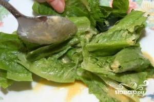 Салатные листья осторожно, чтобы не повредить их нежную структуру, заправить соусом. 