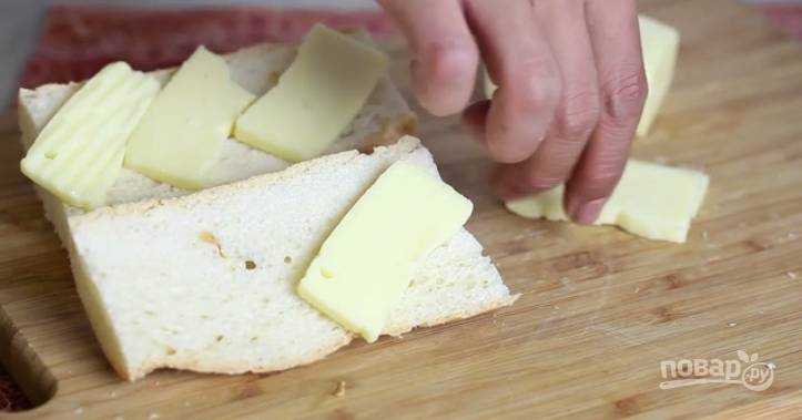 2. Смажем каждый кусочек багета маслом, посыпем специями и поверх каждого поместим сыр. 