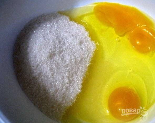1.Перед тем, как приготовить медовик быстрый, достаньте из холодильника масло. Включите на разогрев духовку. В тарелку вбейте яйца, всыпьте сахар.