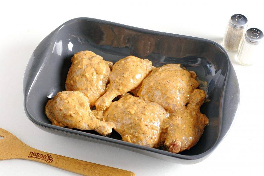 Затем переложите курицу в форму для запекания. Сверху смажьте мясо остатками маринада. Запекайте блюдо в духовке при температуре 180-200 градусов до появления румяной корочки сверху.
