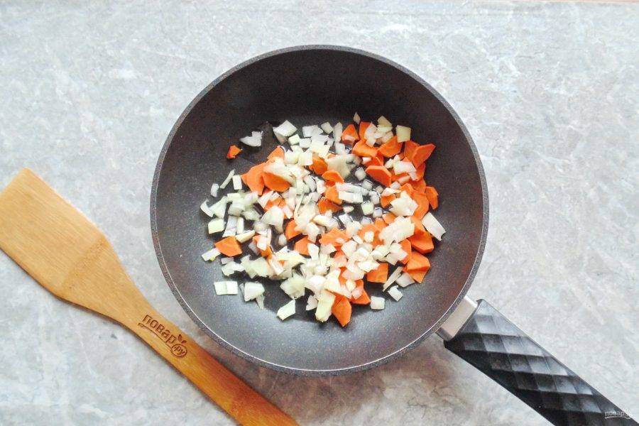 Морковь и лук очистите, ополосните. Нарежьте произвольно и мелко. Выложите в сковороду с маслом и на небольшом огне начинайте обжаривать.