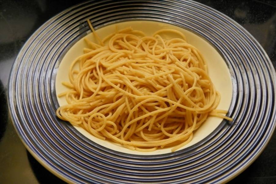 3. По порционном тарелкам разложите спагетти. Если соус получился недостаточно жидким, то смело добавьте в него половину черпака воды, в которой варились спагетти. 
