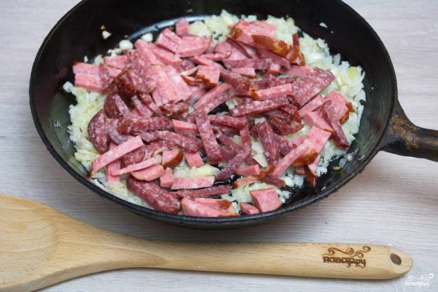 Добавьте нарезанное мясо. Перемешайте и обжарьте все вместе около 3-5 минут, постоянно помешивая.