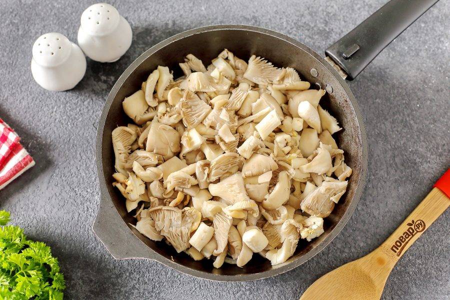 Вешенки тщательно промойте, нарежьте произвольно, но не слишком мелко и добавьте в сковороду. Когда грибы пустят сок, накройте сковороду крышкой и томите периодически помешивая 10 минут.